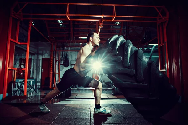 Shirtless man flipping heavy tire — Stock Photo, Image