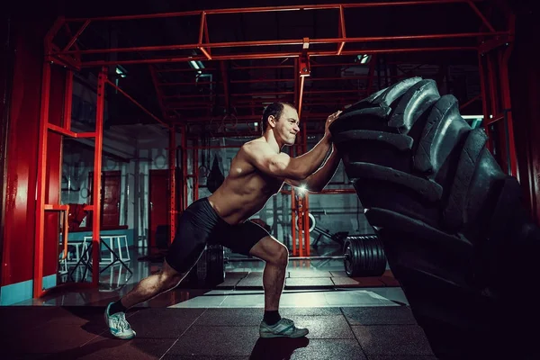 Shirtless man flipping zware banden — Stockfoto