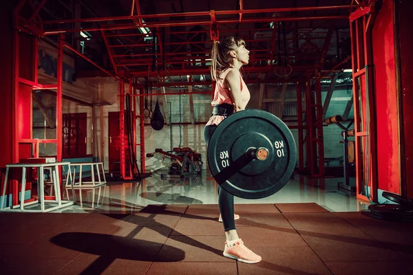 Fitness femenina haciendo ejercicio de levantamiento de pesas con barra de peso — Foto de Stock