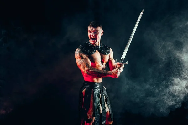 Grave barbaro in costume di pelle con spada — Foto Stock