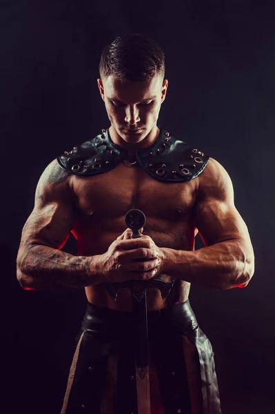 Severe barbarian in leather costume with sword — Stock Photo, Image