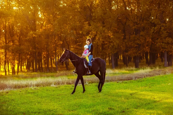 Mãe e filha montando um cavalo — Fotografia de Stock