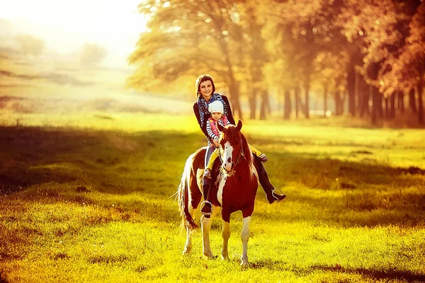 Mãe e filha montando um cavalo — Fotografia de Stock