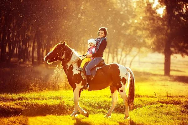 Madre e hija montando un caballo — Foto de Stock