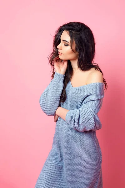Retrato de la joven modelo expresiva en suéter de punto azul sobre fondo de estudio rosa — Foto de Stock