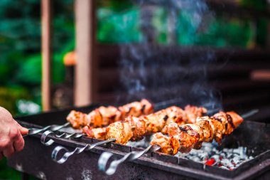 Metal şişte pişen ızgara kebap. Barbeküde pişmiş et. Geleneksel doğu yemeği, şiş kebap. Kömür ve alevler üzerine ızgara, piknik, sokak yemekleri