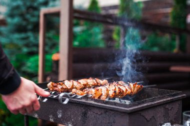 Metal şişte pişen ızgara kebap. Barbeküde pişmiş et. Geleneksel doğu yemeği, şiş kebap. Kömür ve alevler üzerine ızgara, piknik, sokak yemekleri