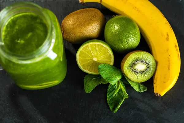 Batido verde licuado con ingredientes en la tabla de madera de piedra —  Fotos de Stock