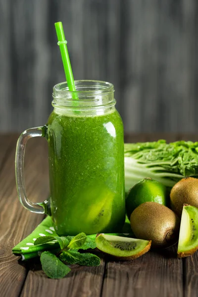 Misturado smoothie verde com ingredientes na mesa de madeira selectiv — Fotografia de Stock