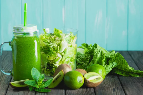 Licuado batido verde con ingredientes en la mesa de madera selectiv —  Fotos de Stock