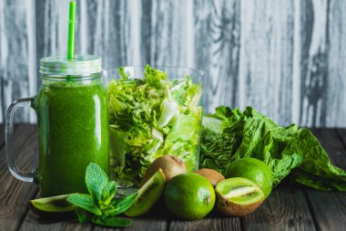 Ahşap masa selectiv sitesinde maddeler ile harmanlanmış yeşil smoothie