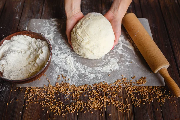 Womans hands knead dough