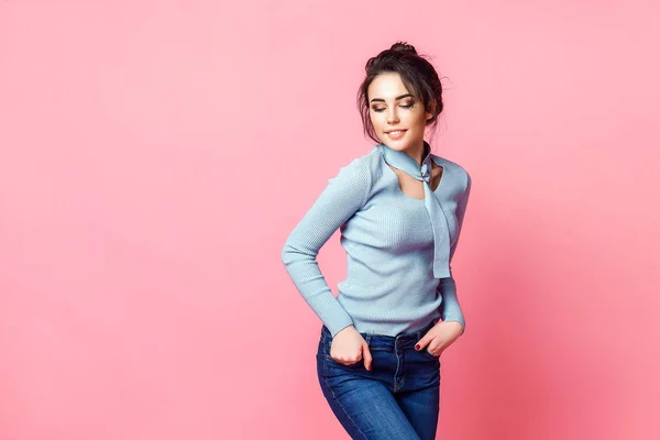Estúdio tiro de feliz jovem de cabelos justos mulher vestida casualmente jeans e blusa azul. fundo rosa. espaço de cópia — Fotografia de Stock