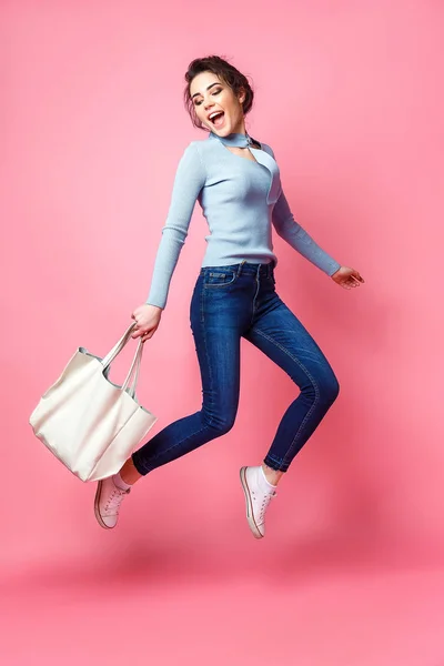 Mulher alegre pulando com bolsa — Fotografia de Stock