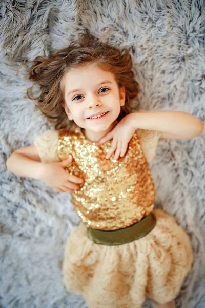 Girl in golden dress on fur