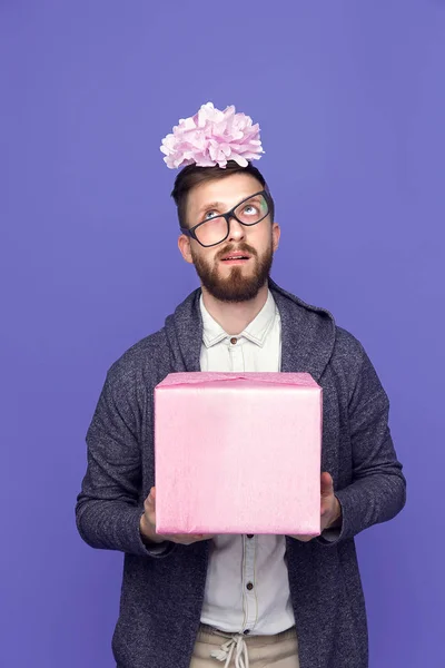 Betäubter Mann mit rosa umwickeltem Geschenk — Stockfoto