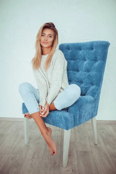 Portrait of pretty blonde woman sits on a chair. — Stock Photo, Image