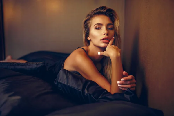 Schöne Frau auf dem Bett liegend Draufsicht — Stockfoto