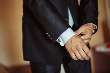 Adam gömleğinin kelepçeleri takılır.