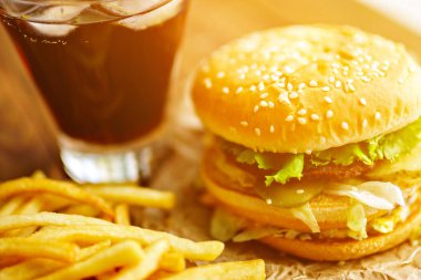 Burger patates kızartması ve kola ahşap arka plan üzerinde ile Kraft kağıt üzerinde