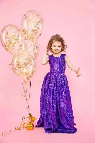 Menina mostrando polegares para cima em balões festivos — Fotografia de Stock