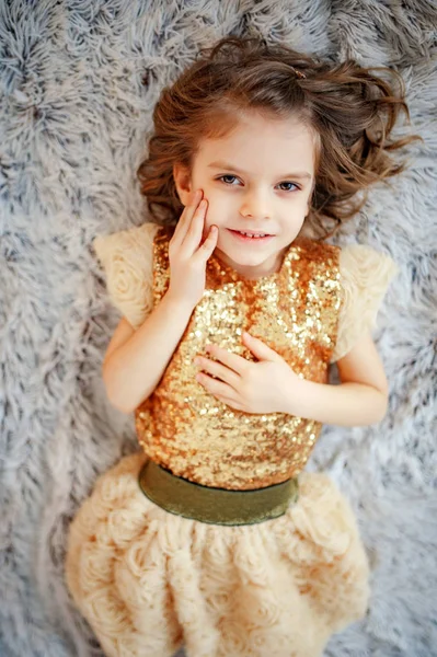 Дівчина в золотій сукні на хутрі — стокове фото