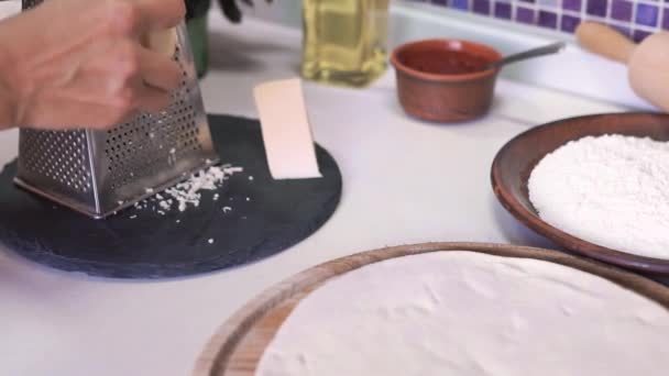 Koken, eten en huis concept - close up van vrouwelijke handen kaas raspen — Stockvideo