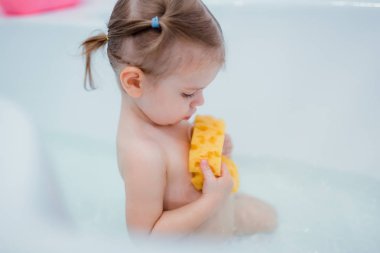 küçük kız banyoda otururken