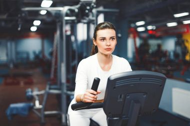 Kapalı Bisiklete binme kadının üzerinde kapalı spor salonu bisikleti kardiyo egzersiz yapması Bisiklet.