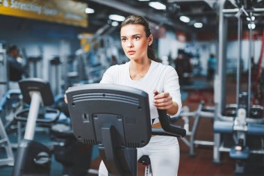 Kapalı Bisiklete binme kadının üzerinde kapalı spor salonu bisikleti kardiyo egzersiz yapması Bisiklet.
