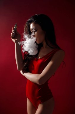 Genç seksi kadın vaping var. Buhar bulutu. Stüdyo çekim.