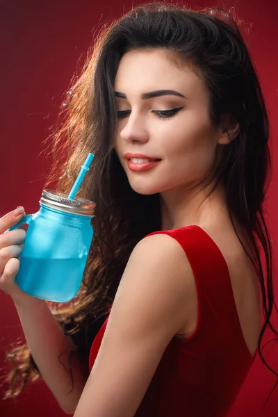 Smiling woman standing with drinking jar in studio — Stock Photo, Image