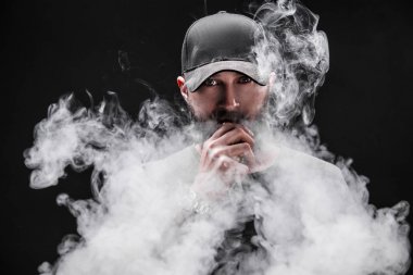 bearded male dressed in a grey shirt, sunglasses and baseball cap vaping clipart