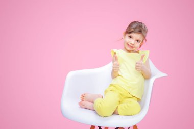 Şık kız pembe üzerinde başparmak gösterilmesini