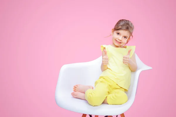 Стильная девушка, показывающая большой палец на розовом — стоковое фото