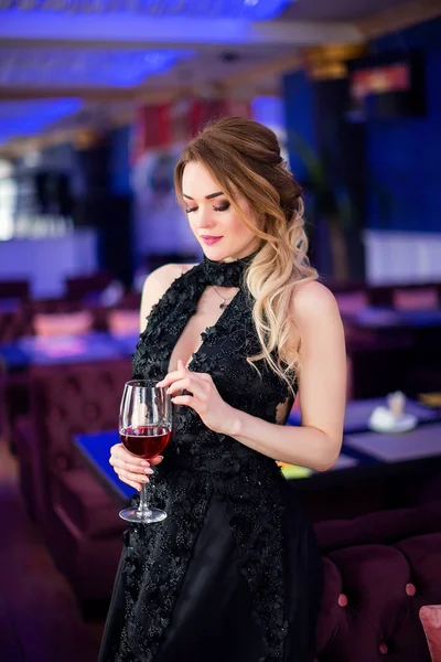 Beautiful sensual woman in elegant clothes sitting in cafe, drinking vine — Stock Photo, Image