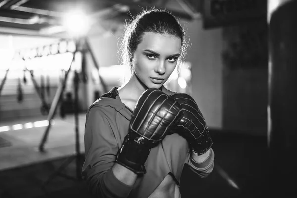 Fit slanke jonge mooie brunette vrouw boksen in sportkleding. Donkere schemerig licht. — Stockfoto