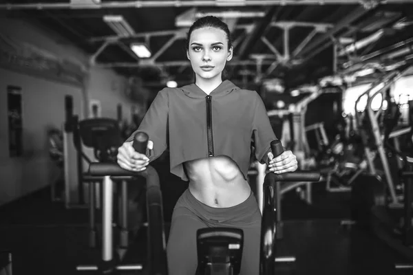 Fitness femenina que utiliza la bicicleta neumática para entrenamiento cardiovascular en el gimnasio . — Foto de Stock