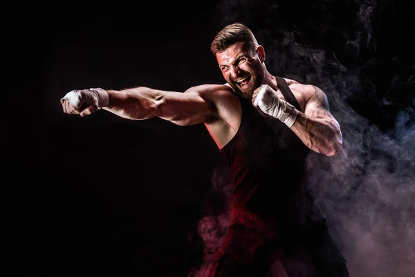 Deportista muay tailandés boxeador luchando sobre fondo negro con humo . — Foto de Stock