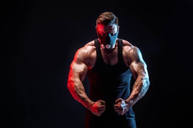 Siyah bir arka plan üzerinde siyah eğitim maskeli güçlü erkek atlet
