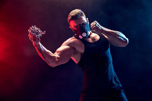 Serious muscular fighter doing the punch with the chains braided over his fist. — Stock Photo, Image
