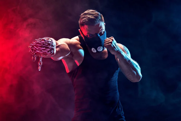 Serious muscular fighter doing the punch with the chains braided over his fist. — Stock Photo, Image
