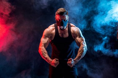 Siyah bir arka plan üzerinde siyah eğitim maskeli güçlü erkek atlet