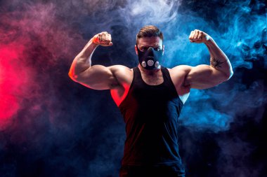 Siyah bir arka plan üzerinde siyah eğitim maskeli güçlü erkek atlet