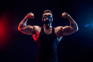 Siyah bir arka plan üzerinde siyah eğitim maskeli güçlü erkek atlet