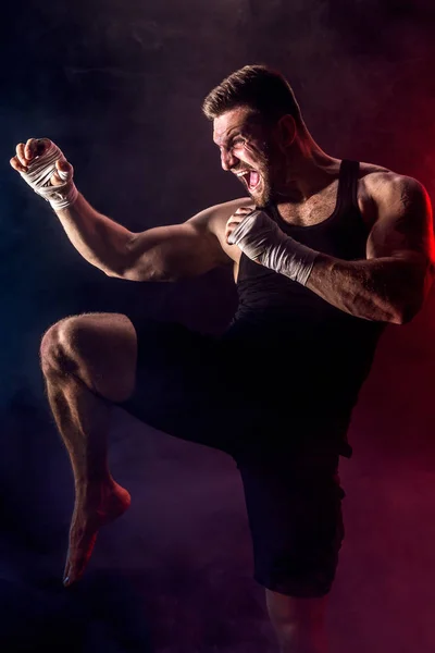 Sportsman muay thai boxer lutando em fundo preto com fumaça . — Fotografia de Stock