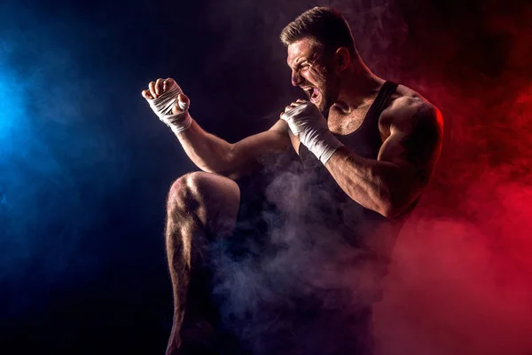 Sportsman muay thai boxer, elleni küzdelem, a fekete háttér, a füst. — Stock Fotó