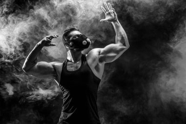 Siyah bir arka plan üzerinde siyah eğitim maskeli güçlü erkek atlet