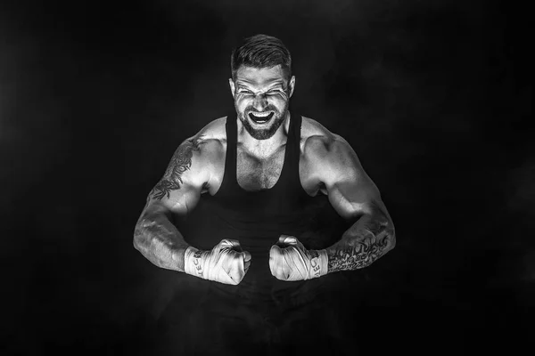 Sportsman muay thai boxer fighting on black background with smoke.