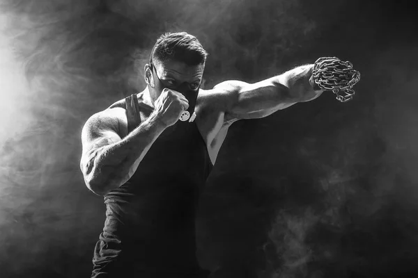 Serio luchador muscular haciendo el puñetazo con las cadenas trenzadas sobre su puño . — Foto de Stock